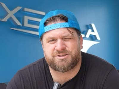 Ricky Schay in a blue cap in front of the Xeela logo on a blue wall